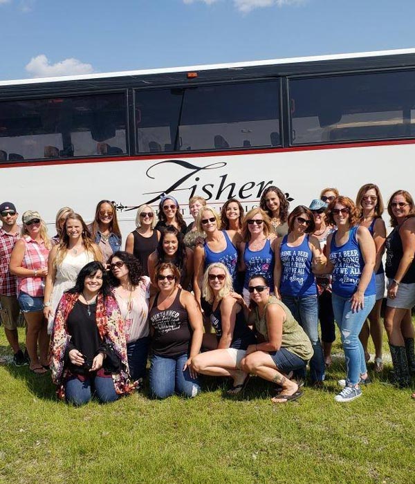 group of women standing next to fisher bus