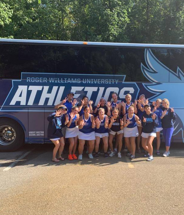 athletic team in front of fisher bus