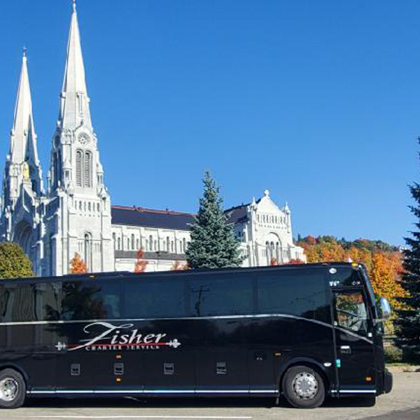 Fisher Bus in front of a beautiful church on a tour