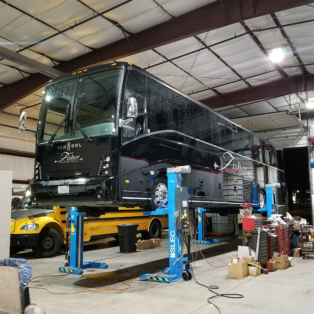 fleet of charter buses in the Fisher Bus Inc repair shop