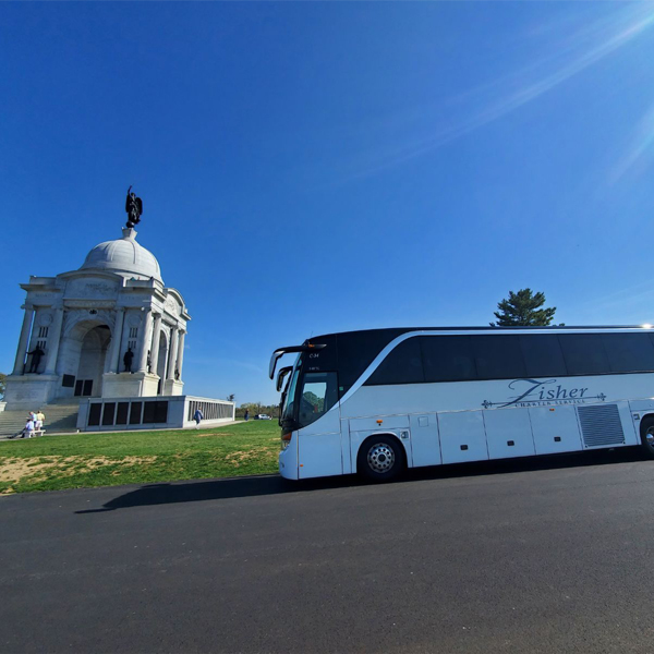 Fisher Bus Inc Full Size Coach bus in front of a monument