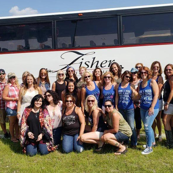 fun group standing in front of a charter bus