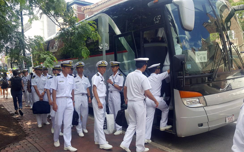 Navy members boarding a charter bus by Fisher Bus Inc